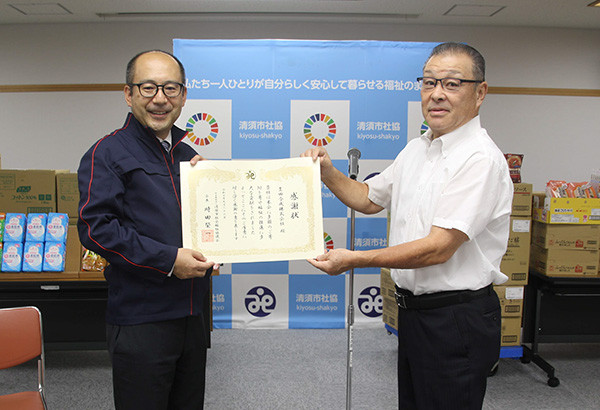清須市社会福祉協議会 時田 榮一会長氏(右)から感謝状を受け取る当社総務部長の佐藤 真臣
